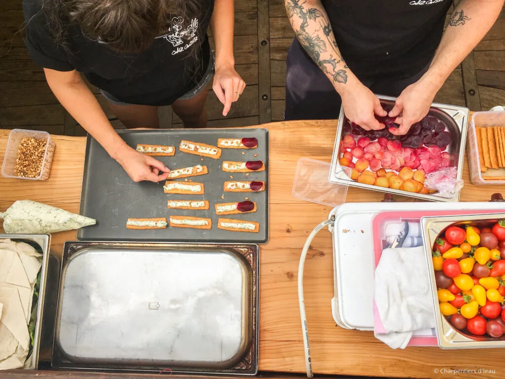Photo où l'on voit les mains des cuisiniers entrain de préparer les repas pour le dîner du resto-flottant