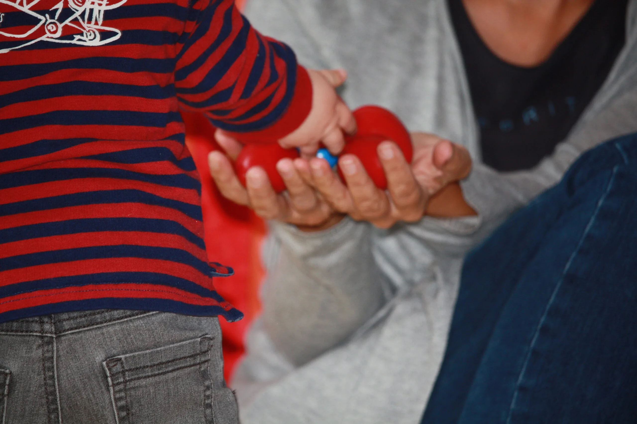 Photo d'un enfant qui donne des jouets à une animatrice.