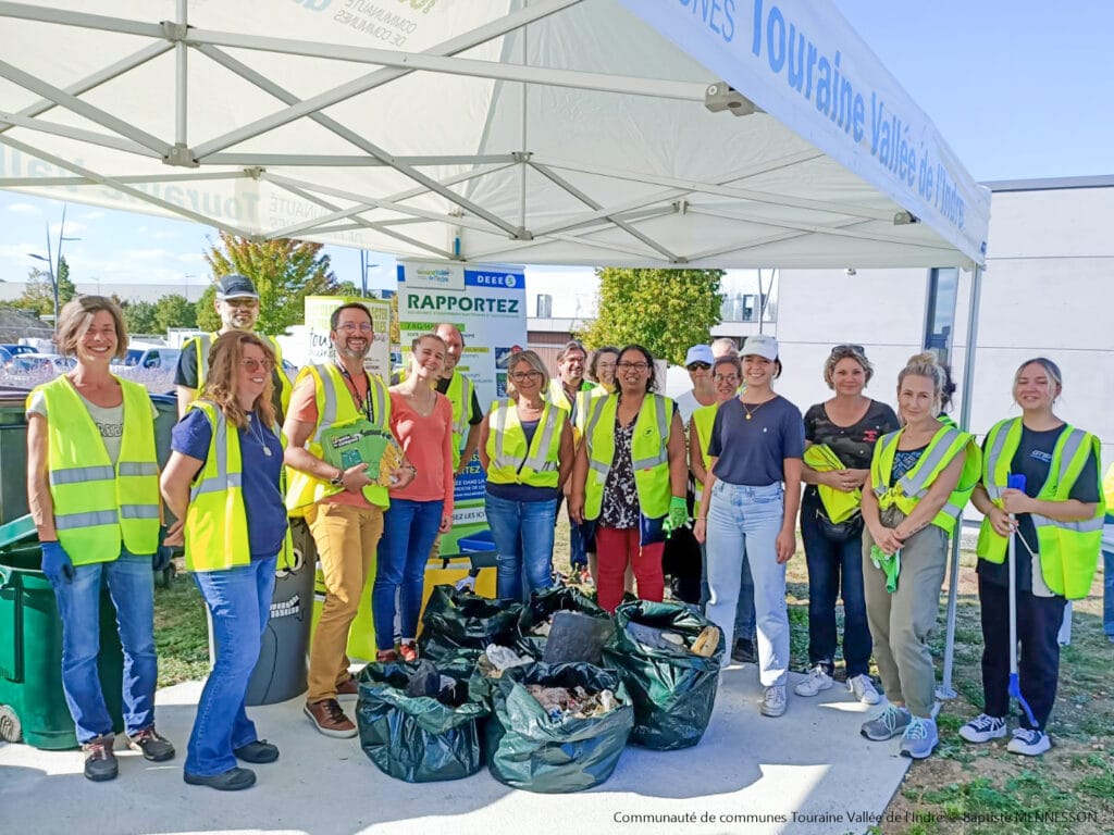 Photo des participants à la collecte de déchets, avec à leurs pieds les sacs de déchets ramassés.