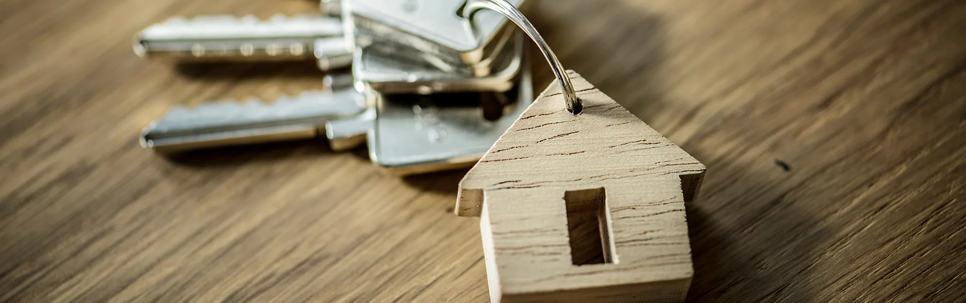 Photo d'Illustration Logement d'urgence : jeu de clés posés sur une table avec un porte clé en bois en forme de maison