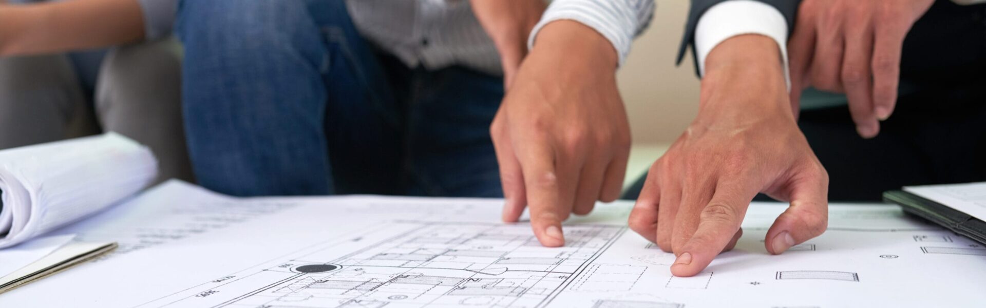 Real estate agent showing building blueprint to client at meeting