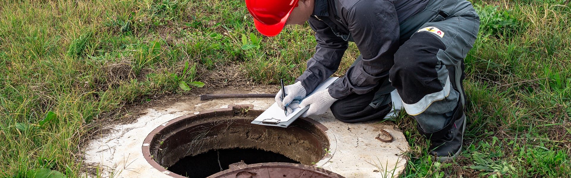 Technicien contrôlant une fosse septique